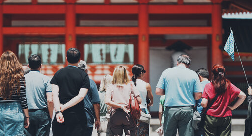 複数の人が赤い鳥居を歩いている様子