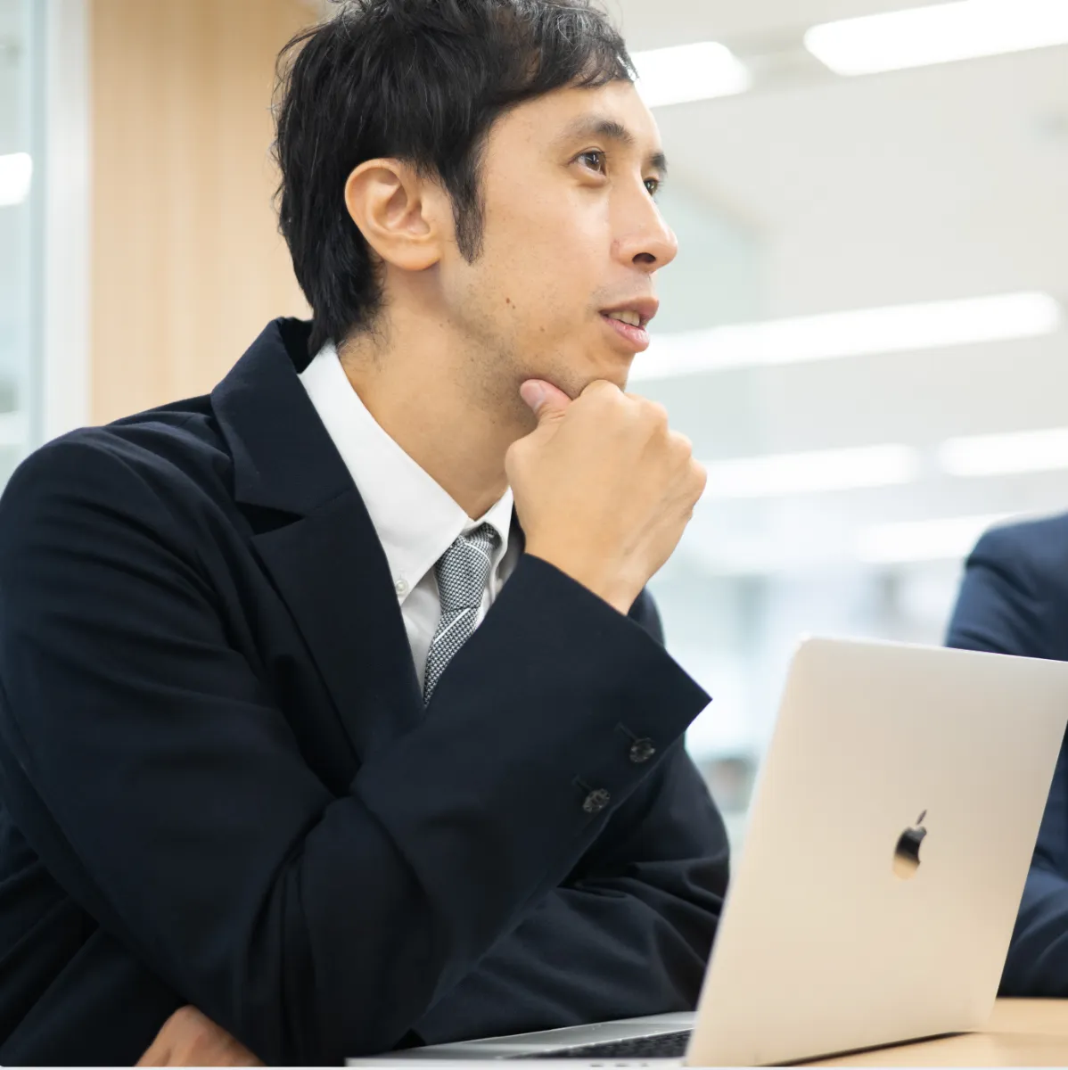 男性がノートパソコンの前に座っている様子